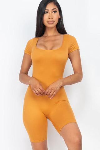 Model wearing a mustard short sleeve scoop neck bodycon romper, made of 92% polyester and 8% spandex, showcasing a tight yet comfortable fit.