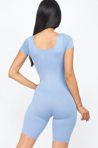 Model wearing a blue short sleeve scoop neck bodycon romper, showcasing a tight yet comfortable fit with stretchy fabric.