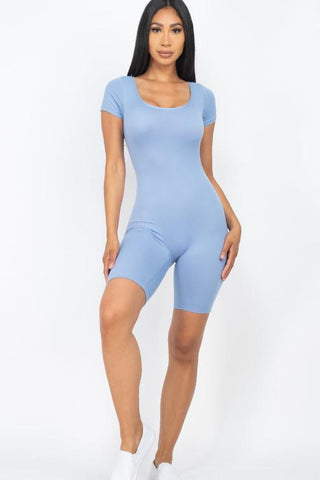 Woman wearing a blue short sleeve scoop neck bodycon romper, highlighting a stretchy and comfortable fit, perfect for casual or active wear.