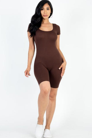 Model wearing a brown short sleeve scoop neck bodycon romper, showcasing a form-fitting and stretchy style made from polyester and spandex.