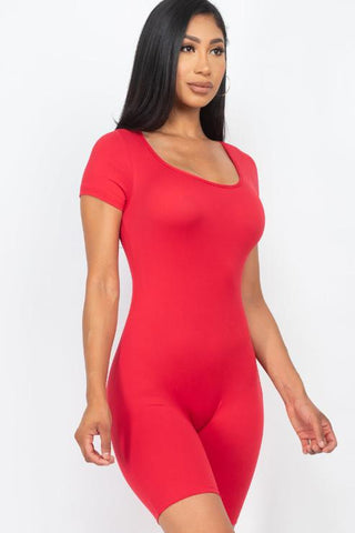 Woman wearing a red short sleeve scoop neck bodycon romper, showcasing a tight yet comfortable fit with stretchy polyester fabric.