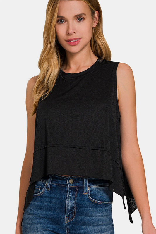 Woman wearing black tank exposed seam slit round neck top with moderate stretch and denim jeans.