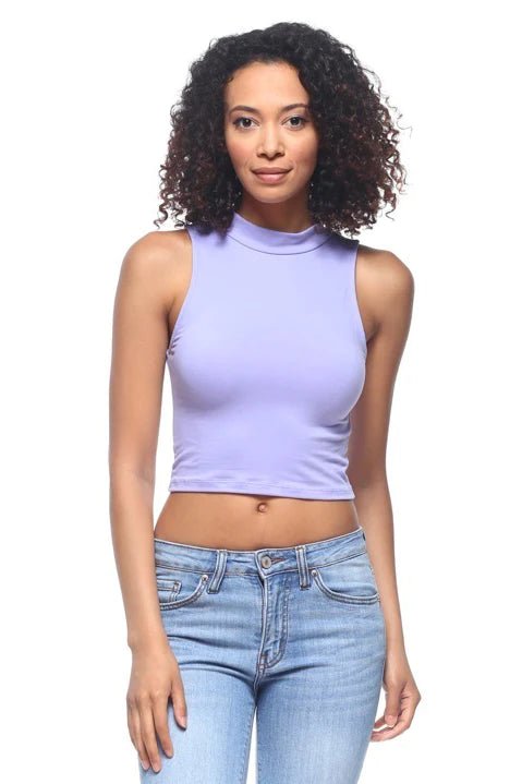 Woman wearing a sleeveless mock neck crop top in lavender, paired with blue jeans.