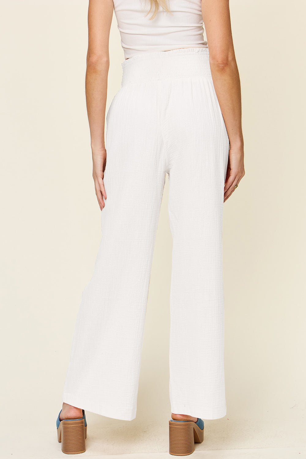 White texture smocked waist wide leg pants made from 100% cotton, shown on model, highlighting opaque design and full size fit.