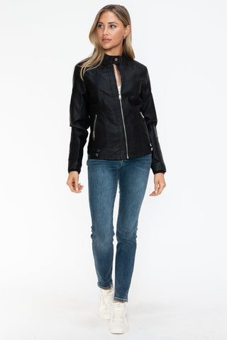 Woman wearing Snobbish Faux Leather Biker Jacket with side zip pockets, black pleather material, basic style, paired with jeans.