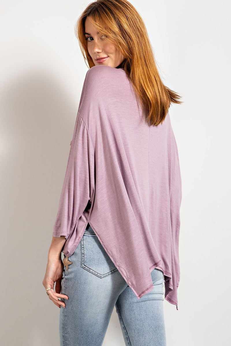 Dusty lavender washed top with rounded neckline and 3/4 sleeves, featuring a boxy oversized fit and side slits.