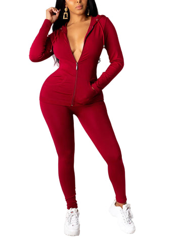 Woman wearing a burgundy solid hoodie leggings set made of polyester and spandex, showcasing comfortable fashion with white sneakers.
