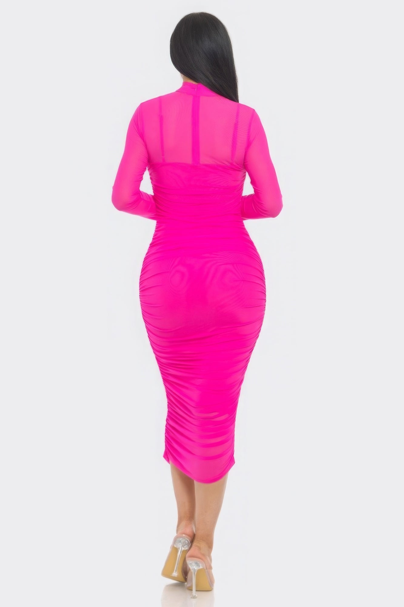 Woman wearing hot pink ruched midi dress with long sleeves and mesh detailing, showcasing elegant and flattering silhouette.