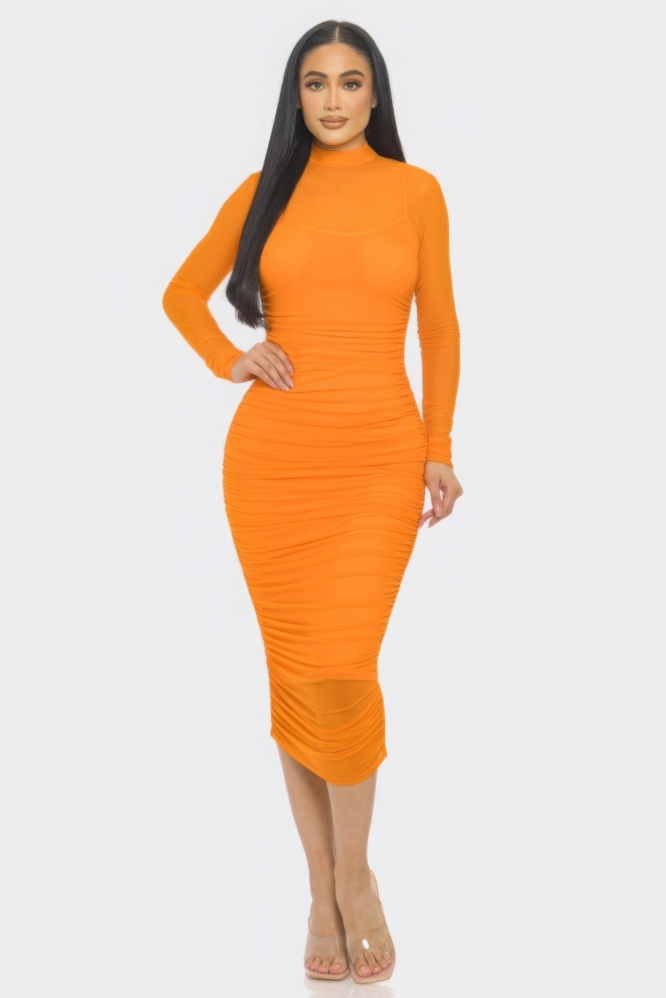 Woman wearing an orange mesh ruched midi dress with long sleeves and smock neck, showcasing a stylish and flattering silhouette.