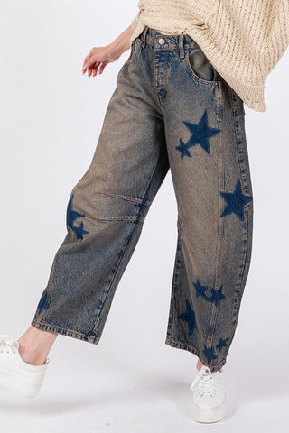 Star wide leg jeans with pockets, featuring blue star design and slightly stretchy 100% cotton fabric, paired with white sneakers.