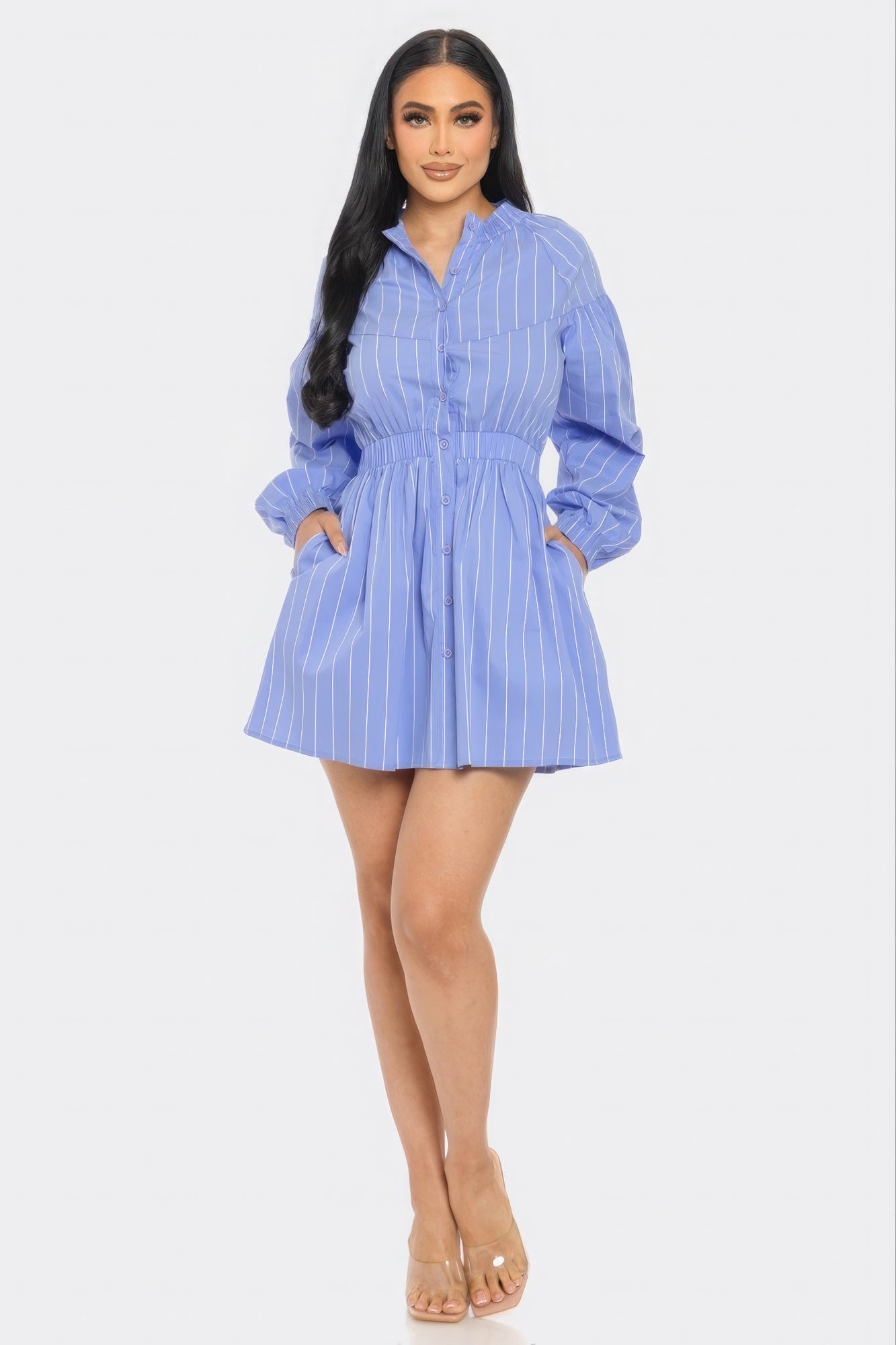 Woman wearing a blue striped mini dress with a flattering fit and flare silhouette, basic collar, and playful dolphin hem.