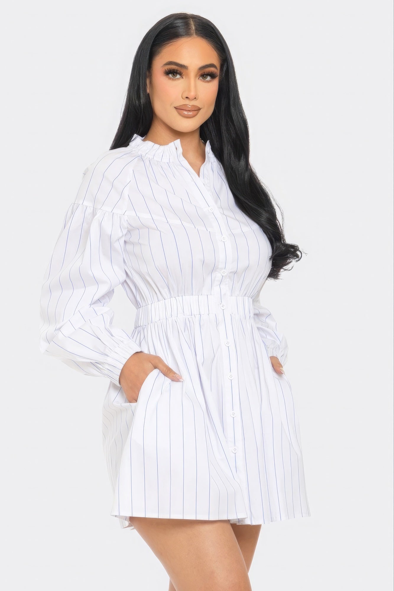 Woman wearing a white and blue striped mini dress with dropped long sleeves and a fit and flare silhouette.