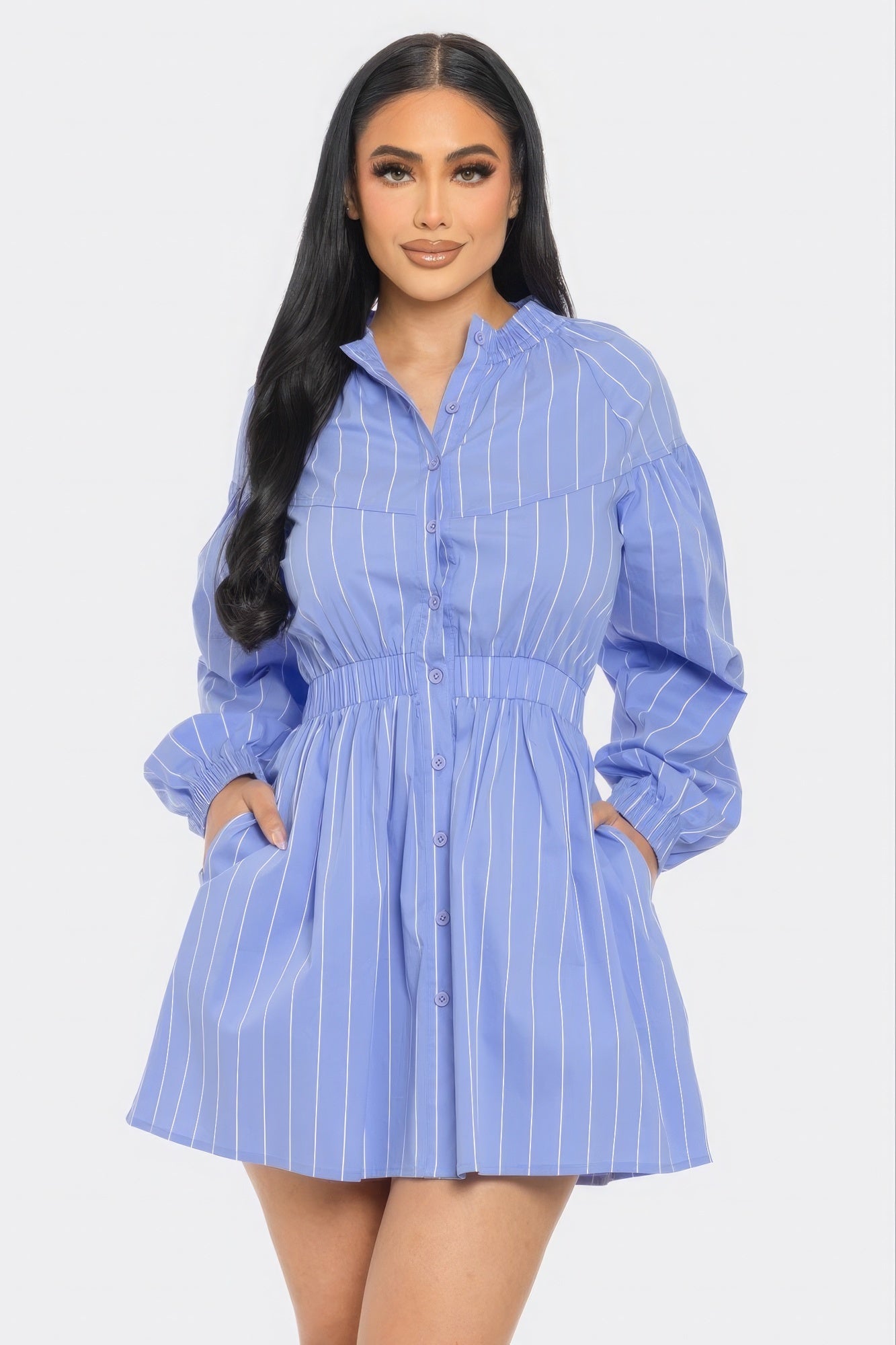 Woman wearing blue striped mini dress with long sleeves and playful dolphin hem.