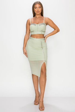 Woman wearing light sage studded stone cami top and slit mini skirt set with mesh back and sweetheart neckline.