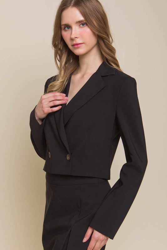 Woman wearing a sleek black button crop blazer made of polyester and spandex, available in small, medium, and large sizes.