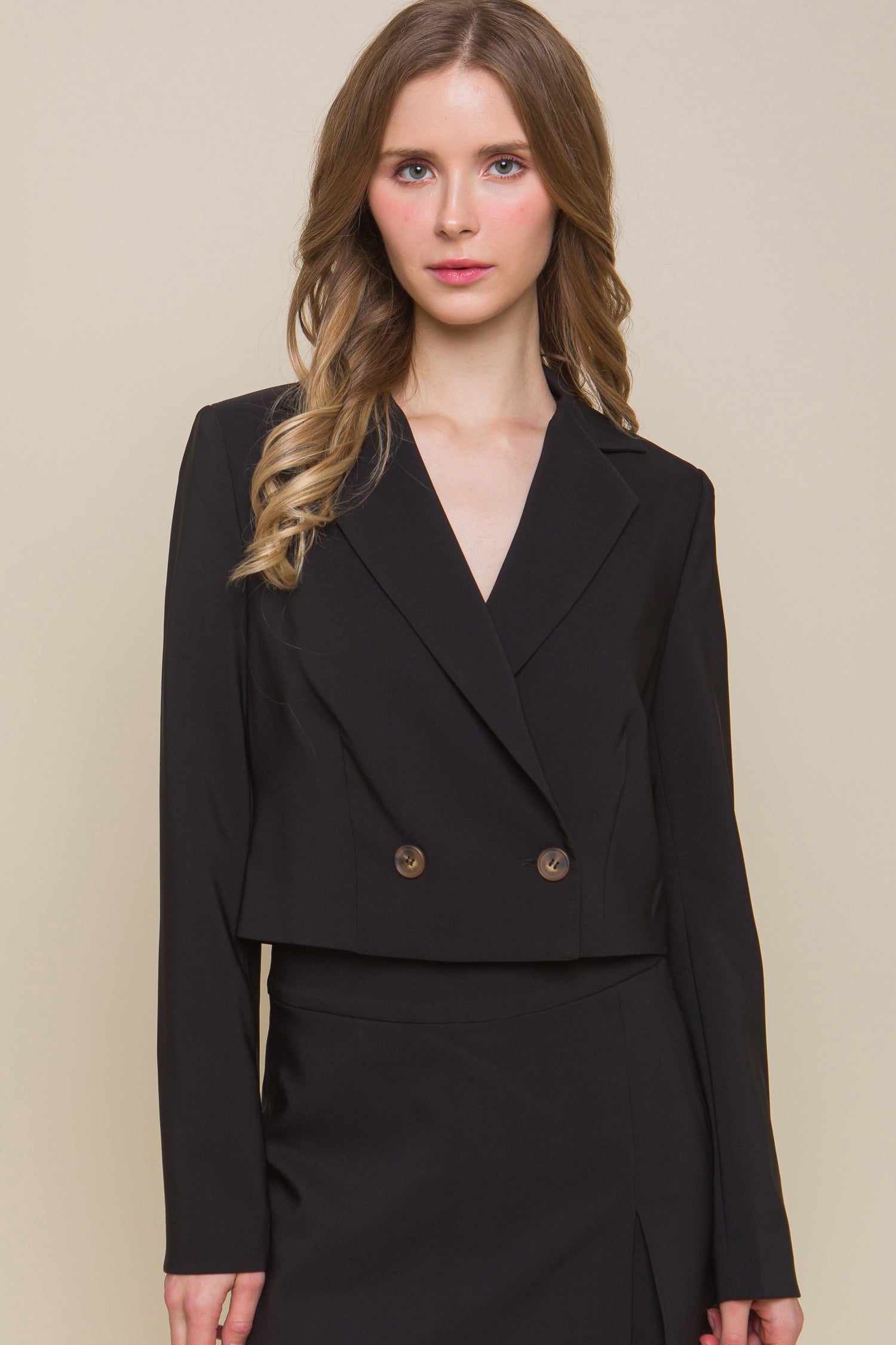 Woman wearing sleek black button crop blazer with double-breasted design, available in small, medium, large sizes.