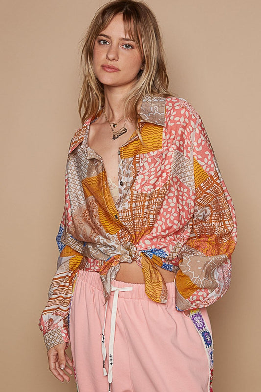 Woman wearing a colorful printed button-down long sleeve shirt with pink pants, styled in a casual look.