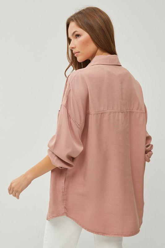 Woman wearing a button-up long sleeve denim shirt made of 100% tencel with no stretch, showcasing a stylish back view design.