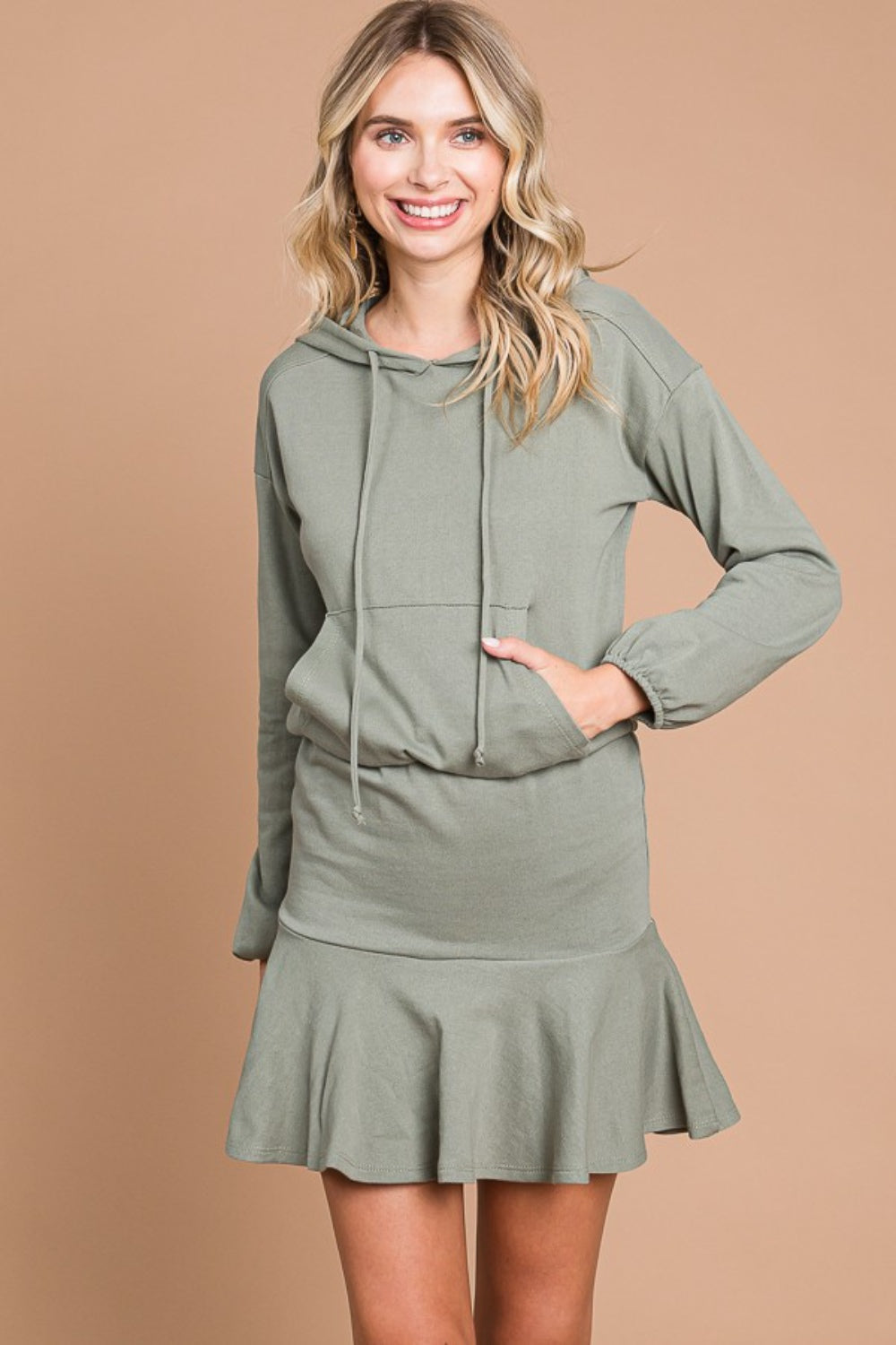 Drawstring dropped shoulder hooded mini dress in green with pocket and ruffled hem, highly stretchy cotton-polyester blend.