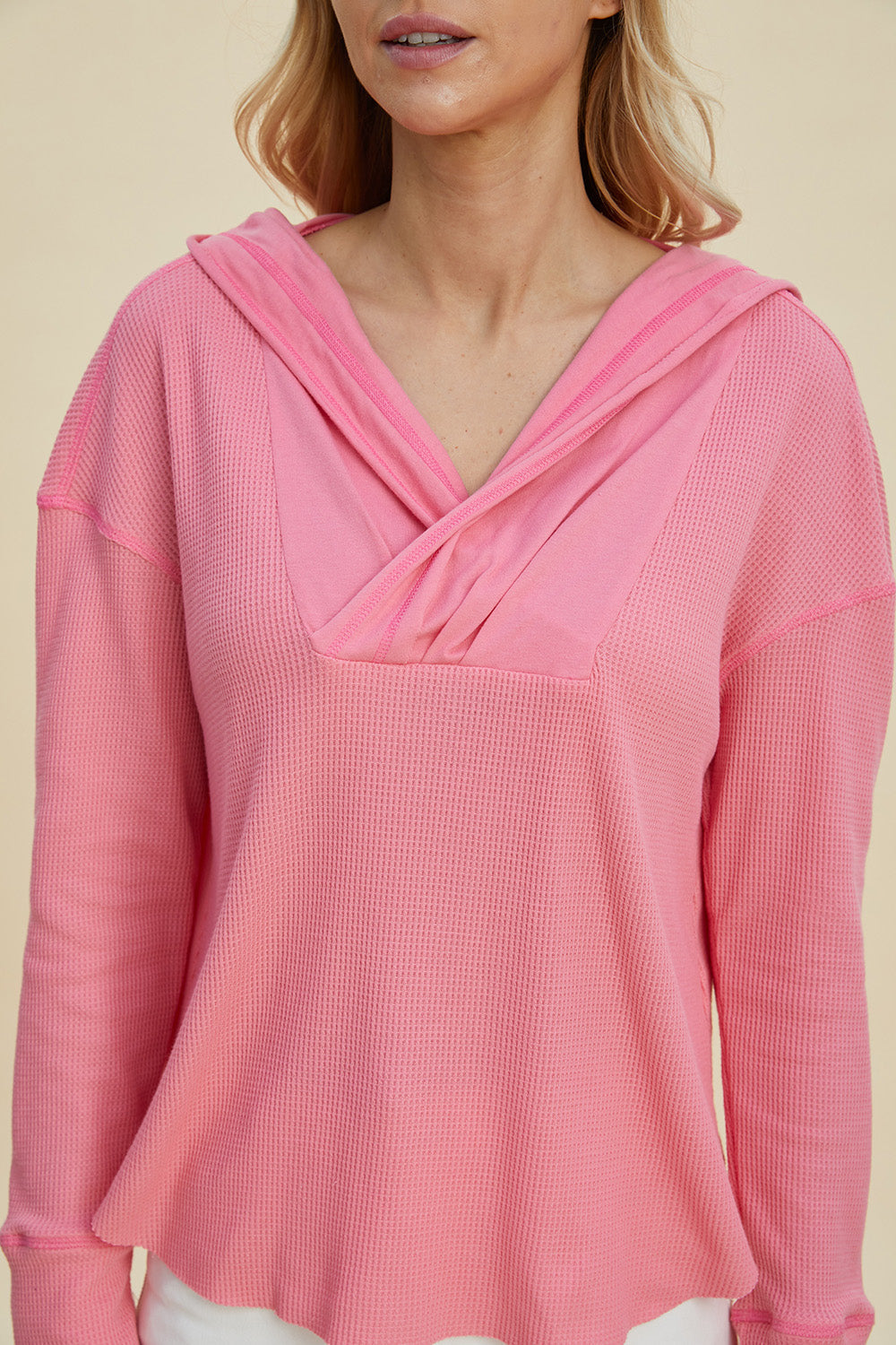 Pink high-low dropped shoulder hoodie with long sleeves and slightly stretchy polyester-cotton blend.