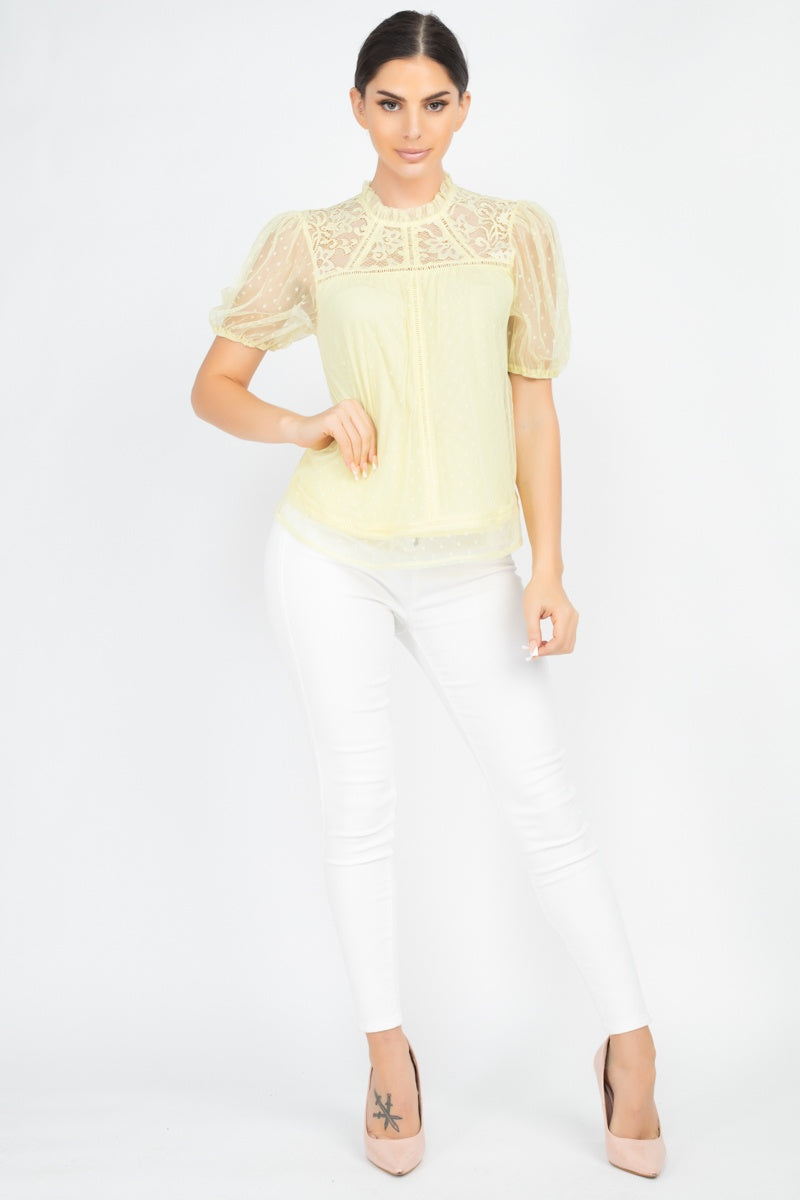 Woman wearing high waist white denim jeans with a sheer yellow lace top.