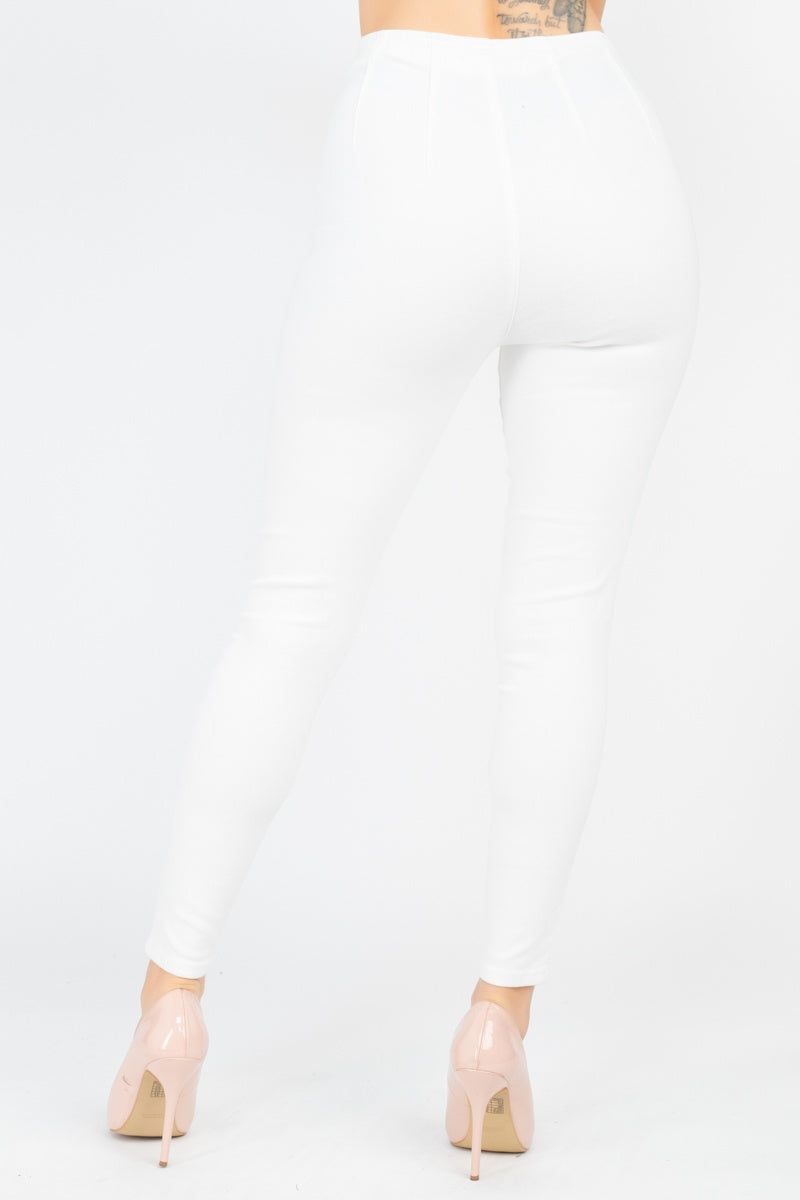 White high waist denim jeans with skinny leg fit and full length, featuring a front o-ring zipper, shown from the back.