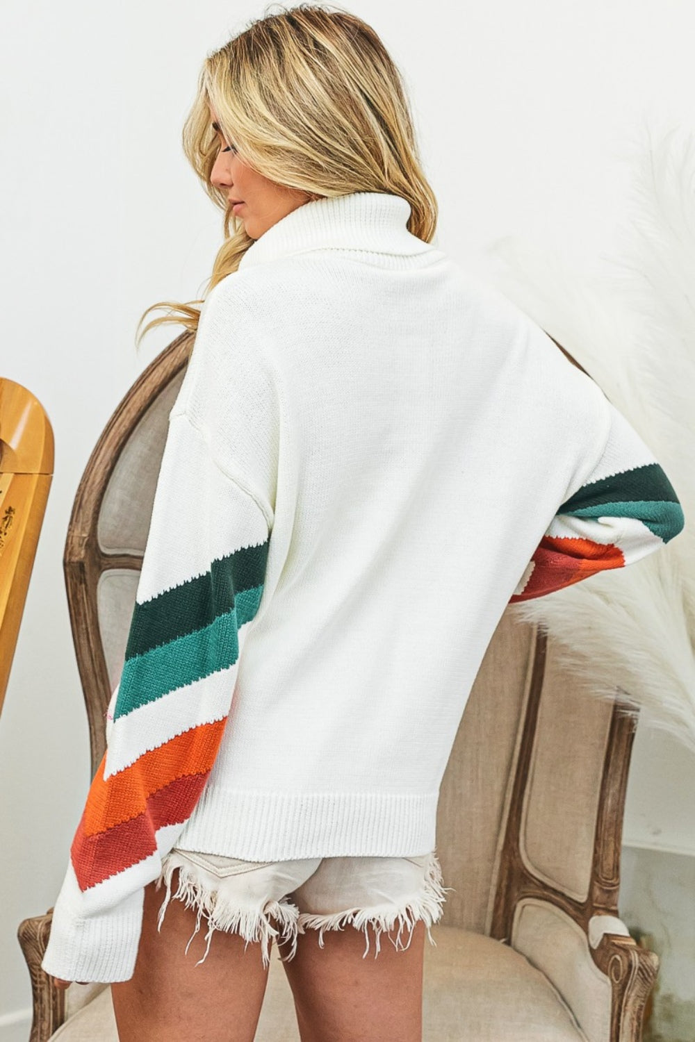 "Model wearing cozy multicolor chevron pattern sweater with turtleneck and half-zip, perfect for versatile casual to dressy looks"