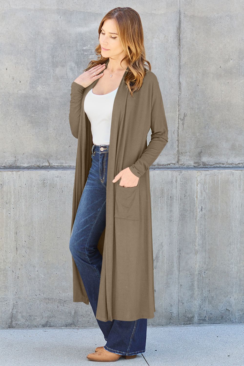 Woman wearing open front long sleeve cover up with pocket, paired with jeans and tank top. Fashionable and comfortable outfit.