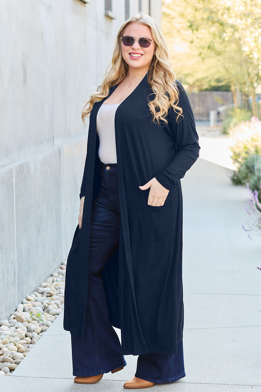 Woman wearing an open front long sleeve cover up with pockets, made of slightly stretchy 95% rayon and 5% spandex material.