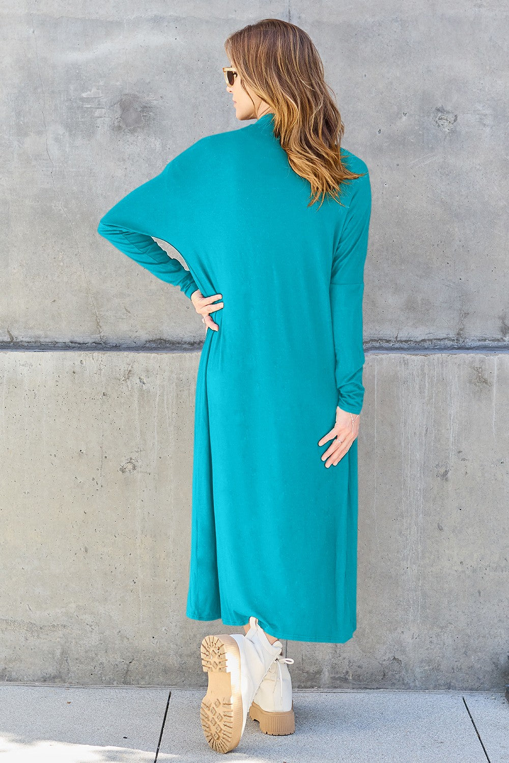 Woman wearing teal open front long sleeve cover up with pockets and slight stretch