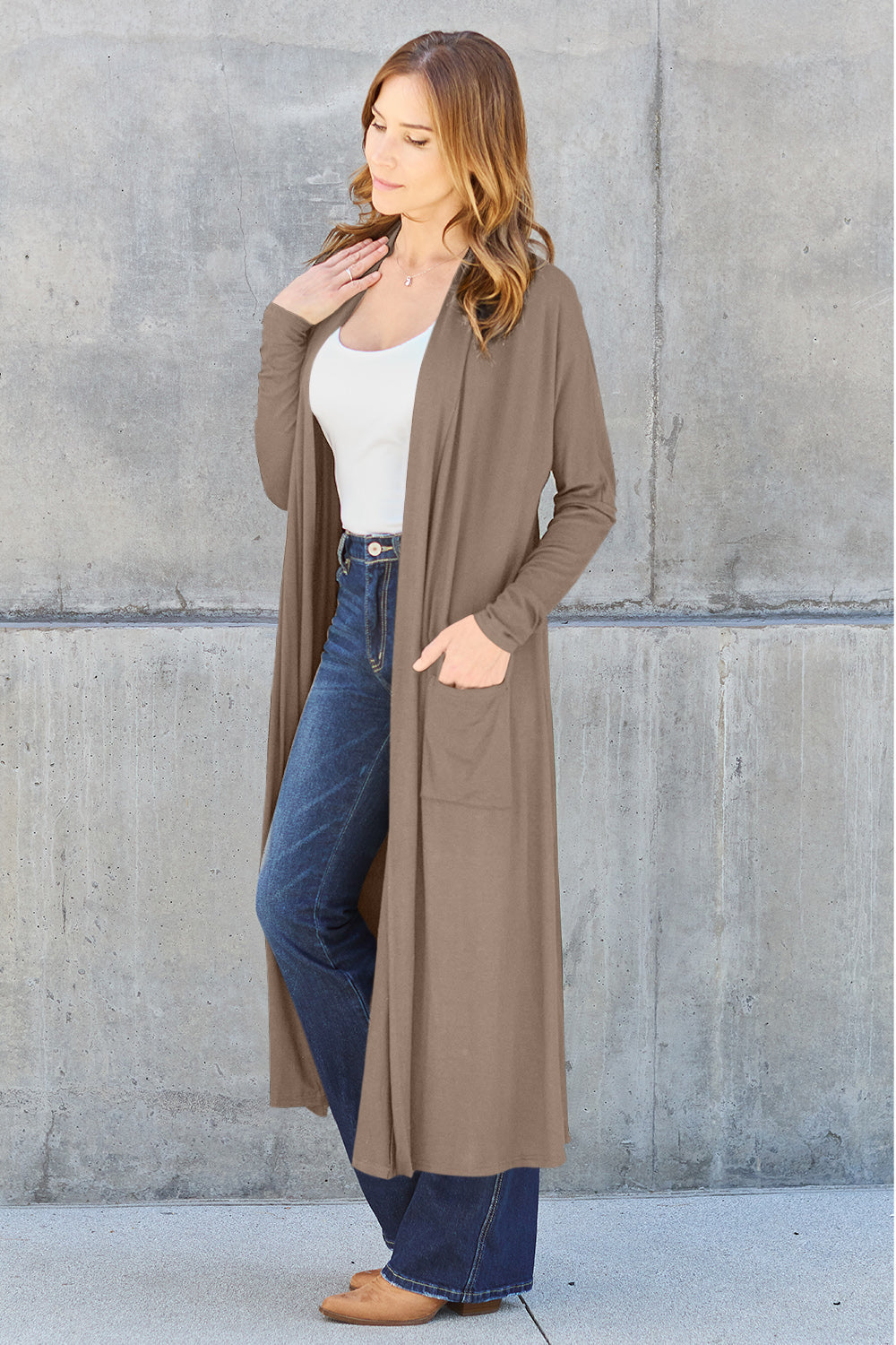 Woman wearing pocketed open front long sleeve cover up in taupe with jeans, perfect for casual wear.