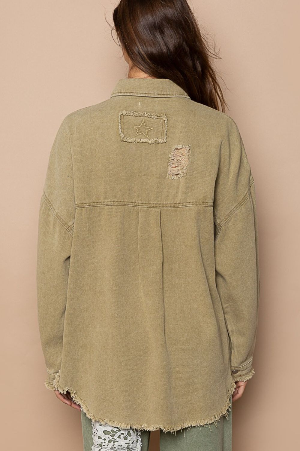 Women's button down raw hem distressed shacket in 100% cotton, featuring a back view with unique detailing.