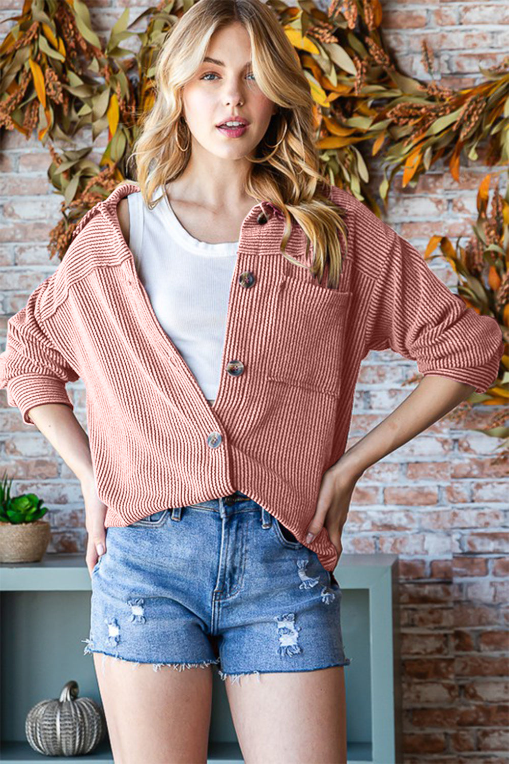 Woman wearing a Reborn J Button Up Long Sleeve Shacket with casual denim shorts, featuring a cozy fall setting.