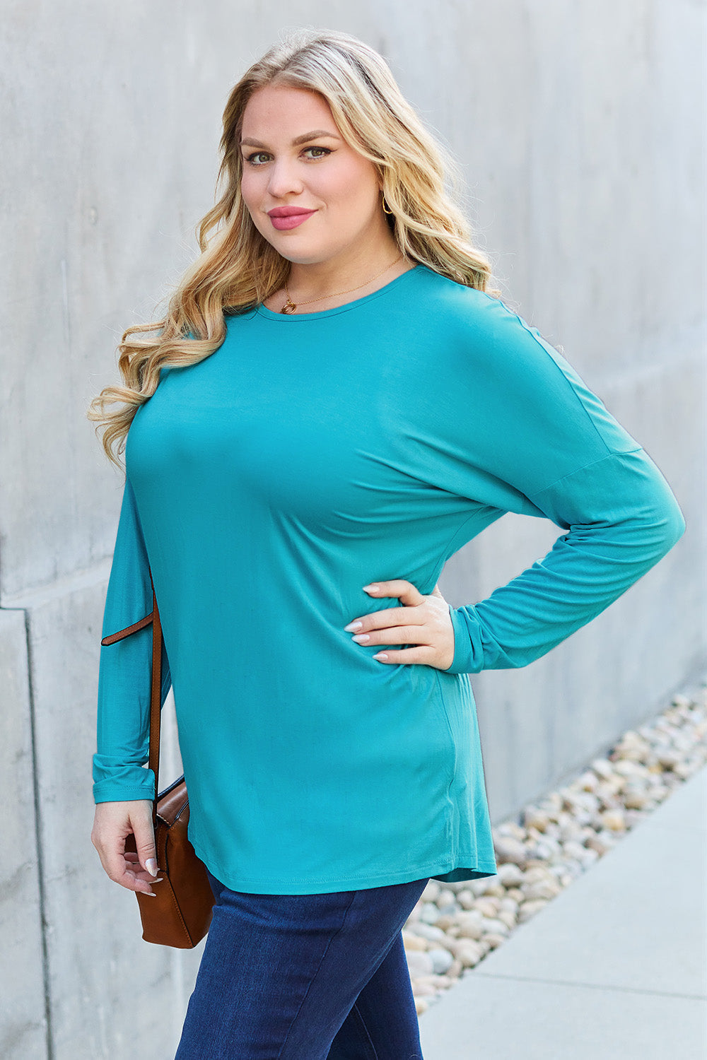 Woman wearing a turquoise round neck dropped shoulder T-shirt, full size, made from 95% rayon and 5% spandex.