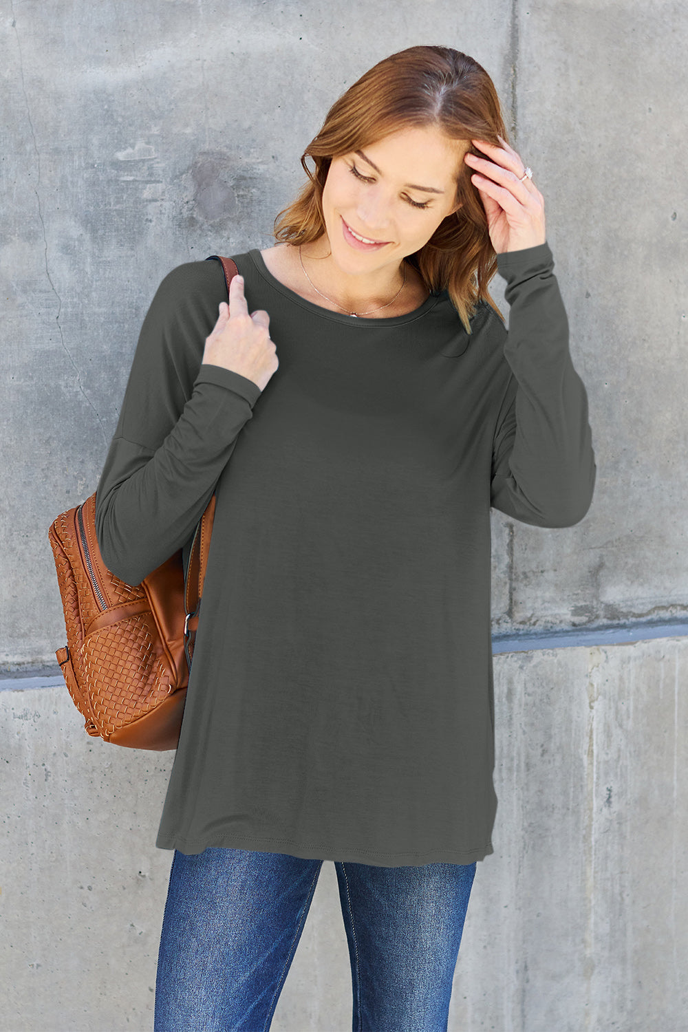 Woman wearing round neck dropped shoulder t-shirt with backpack, casual style.