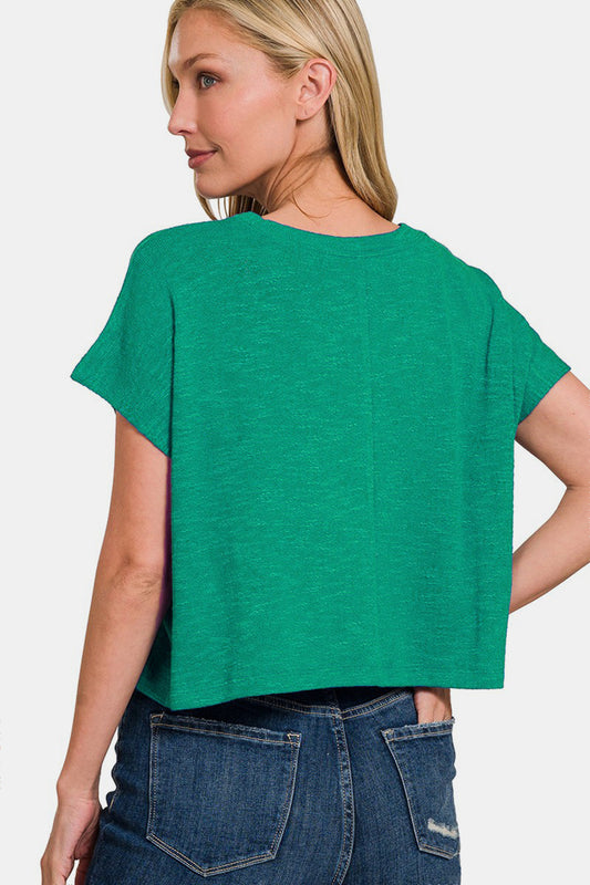 Woman wearing a green round neck short sleeve T-shirt made of polyester, rayon, and spandex, with blue jeans.