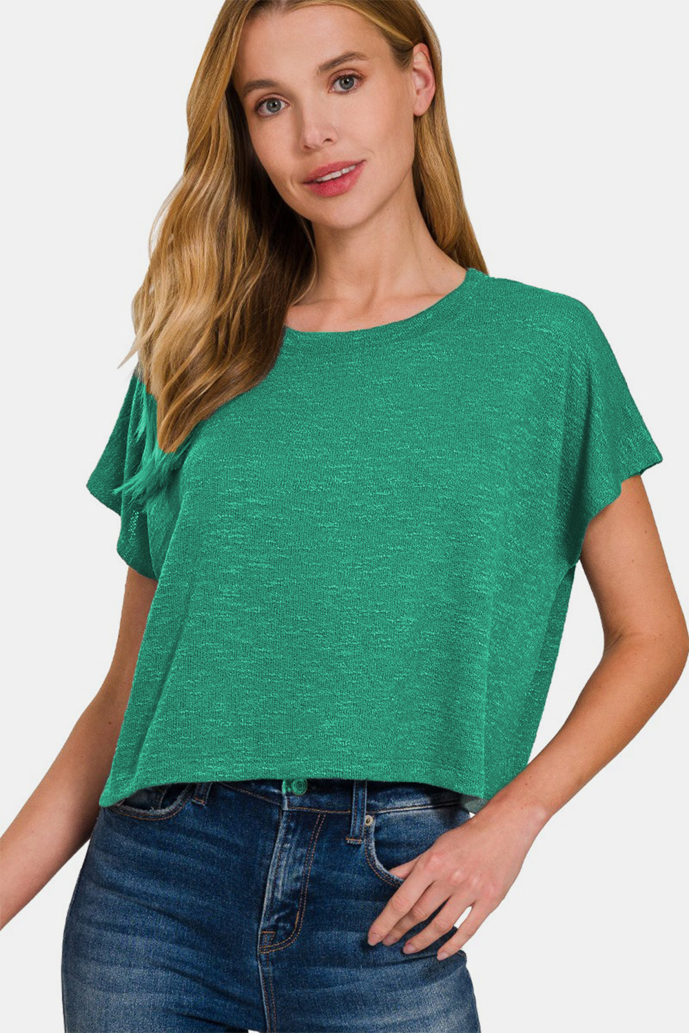 Woman wearing a green round neck short sleeve t-shirt made of polyester, rayon, and spandex, paired with blue jeans.