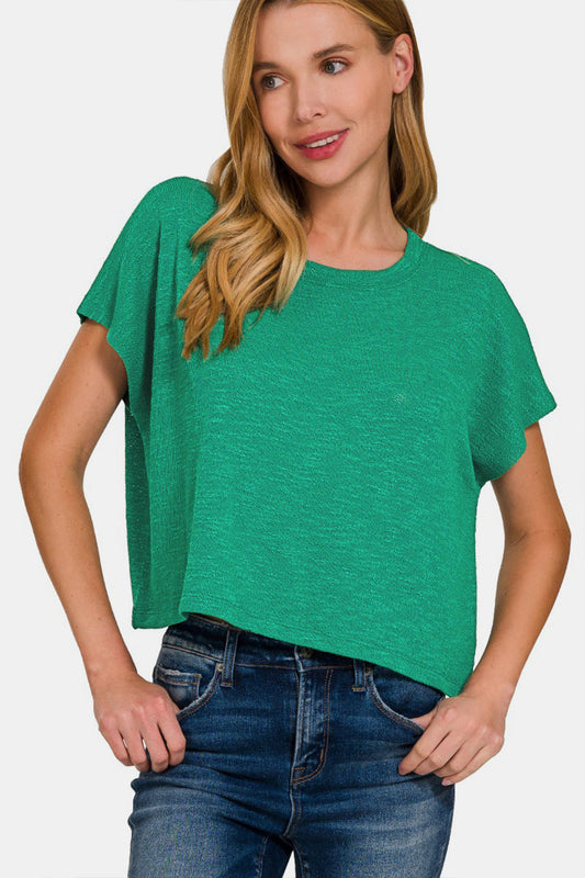 Woman wearing a green round neck short sleeve t-shirt paired with blue jeans, showcasing a casual and comfortable style.