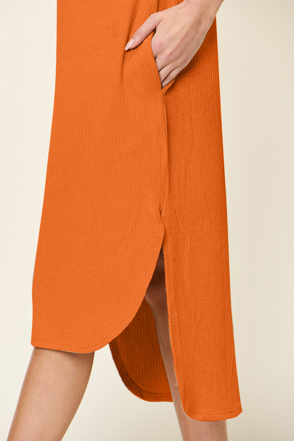 Orange slit dress with round neck and short sleeves, showing a slightly stretchy, opaque fabric of 94% polyester and 6% spandex.