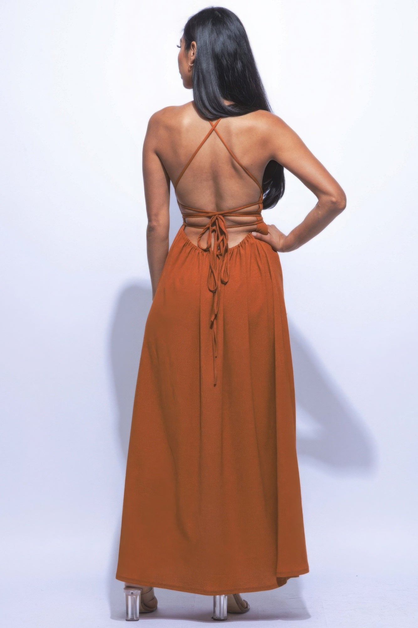 Woman wearing orange side slit maxi skirt with strappy tie back, highlighting a flattering flare silhouette, perfect for any occasion.