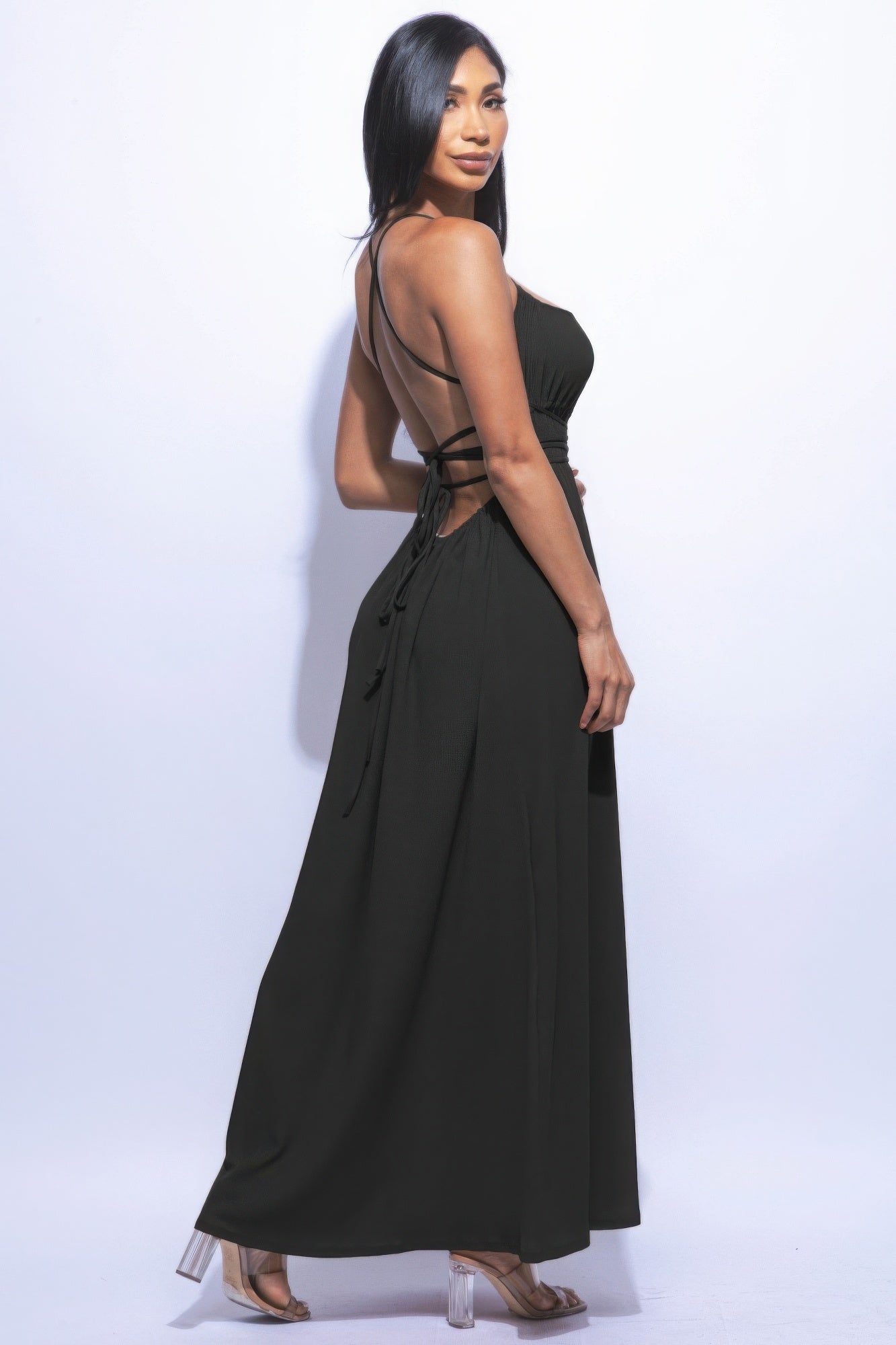 "Woman wearing black side slit maxi skirt with strappy back and heels, showcasing elegant and versatile fashion"