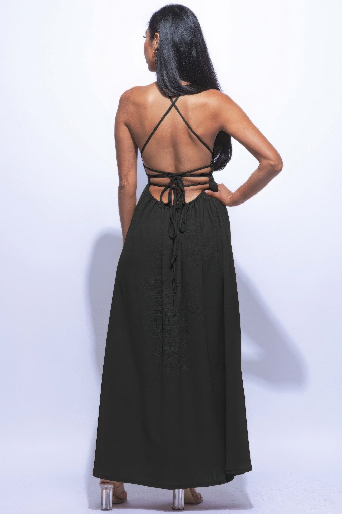 Woman wearing black side slit maxi skirt with strappy tie back, showcasing elegant style and versatility.