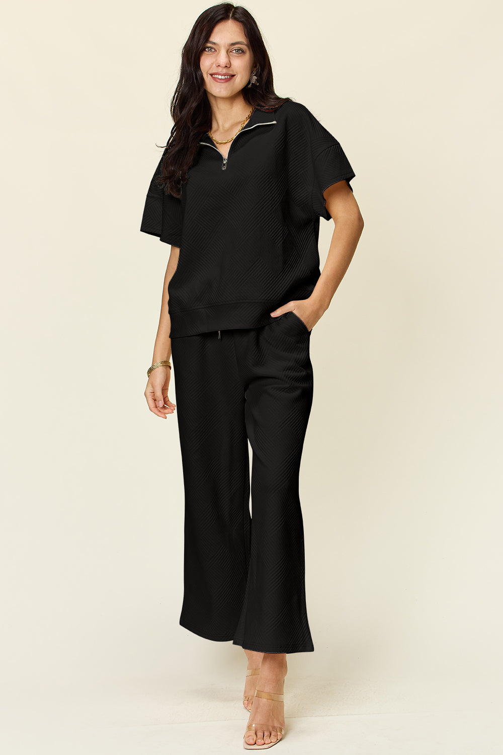 Woman wearing black Texture Half Zip Short Sleeve Top and Pants Set with pockets and drawstring, slightly stretchy fabric.