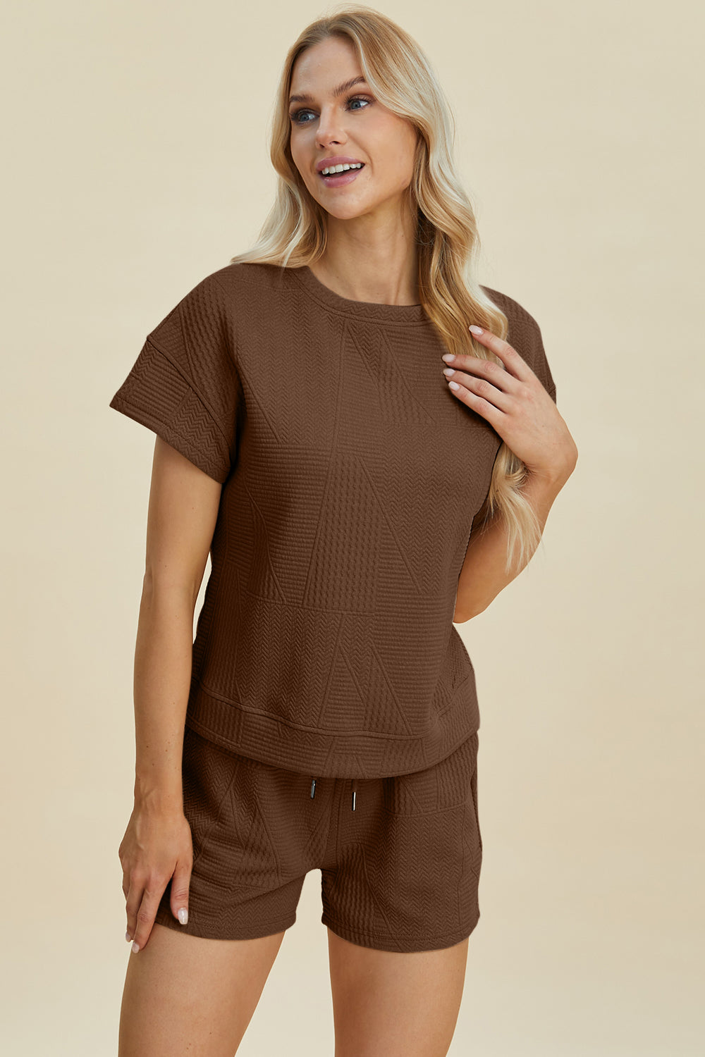 Woman wearing a brown texture short sleeve top and shorts set with pockets and drawstring, made of slightly stretchy polyester blend.