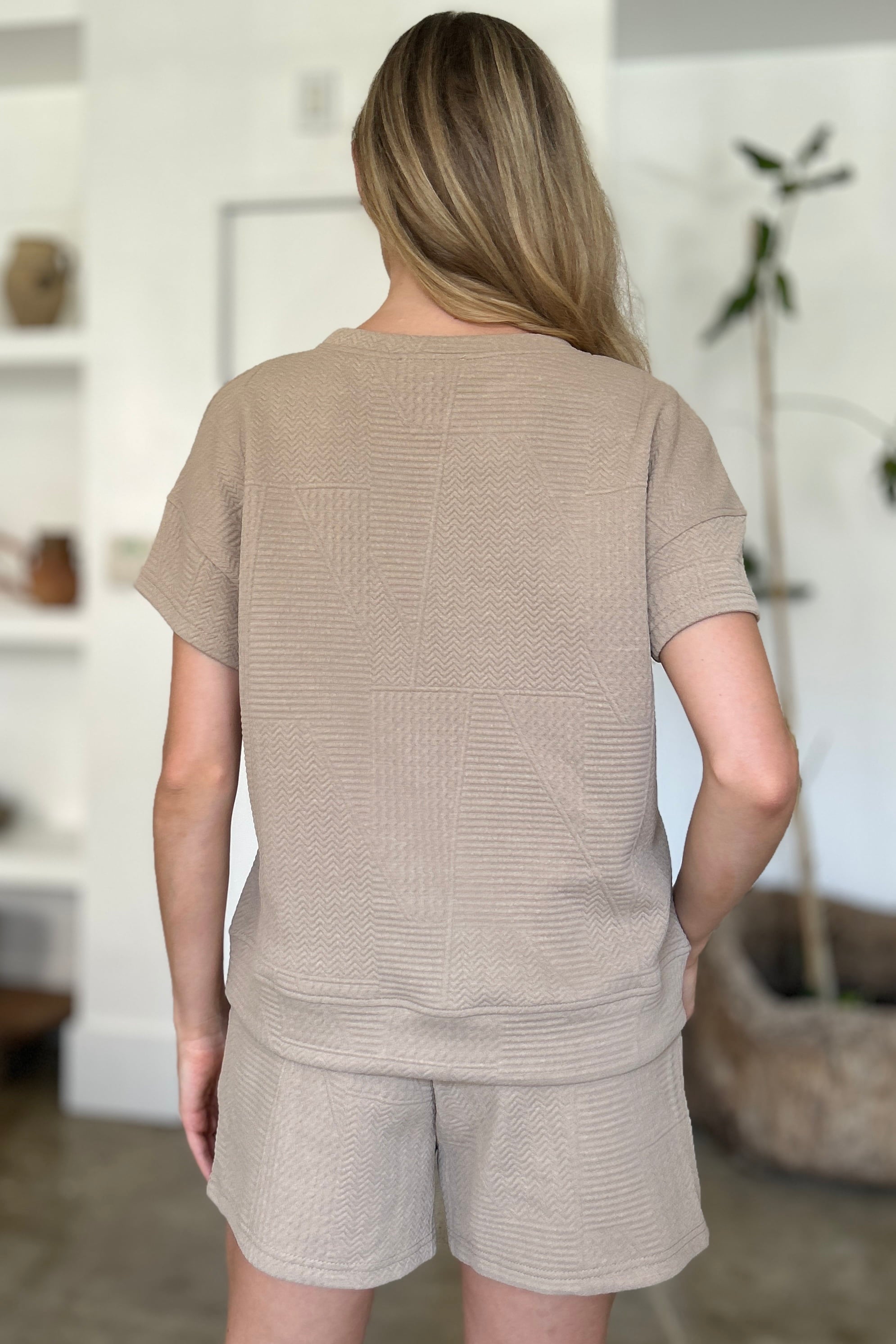 Woman wearing a full size texture short sleeve top and shorts set with pockets and drawstring, made of 98% polyester and 2% elastane.