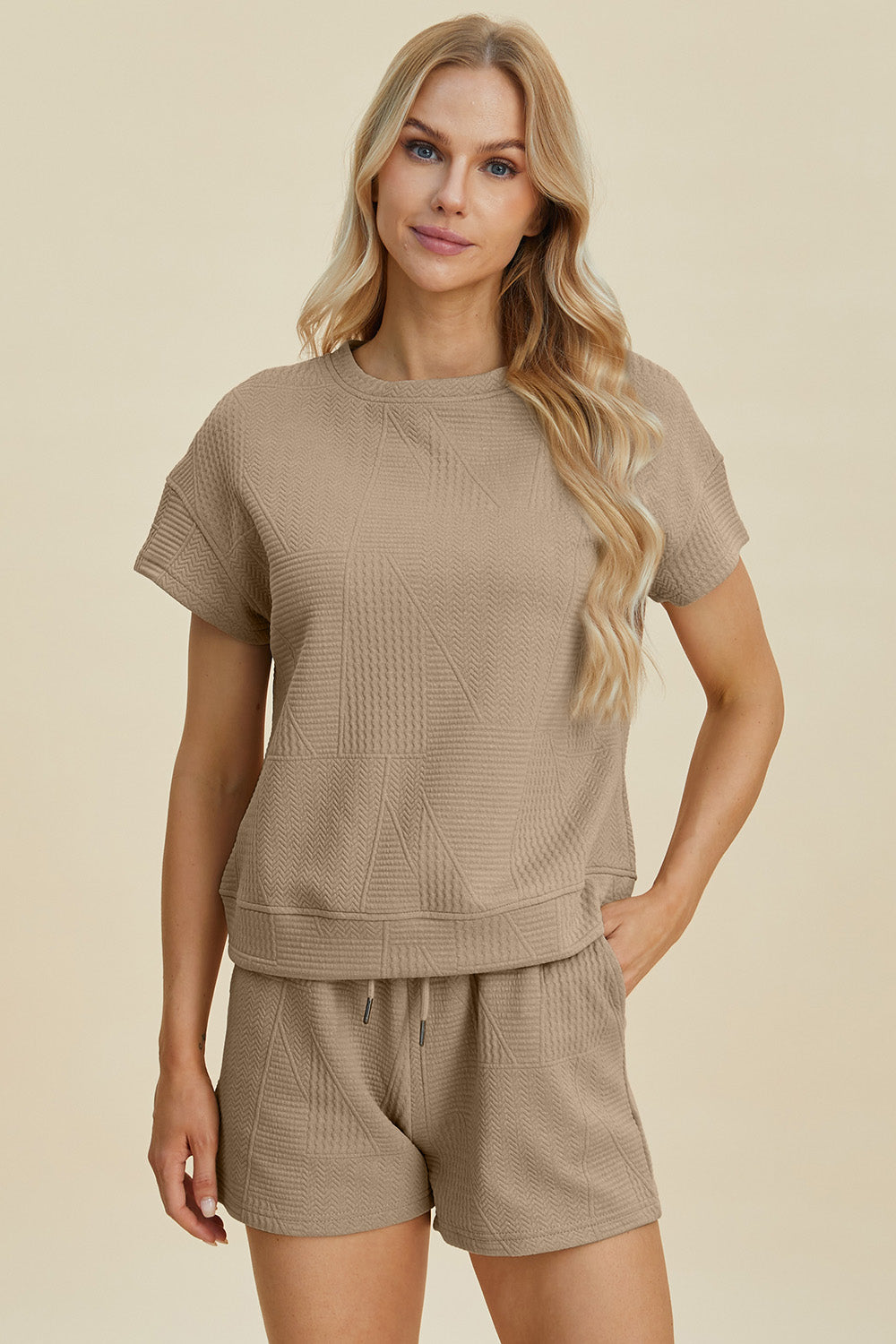 Full size texture short sleeve top and shorts set in beige with pocketed design and drawstring, made of 98% polyester, 2% elastane.