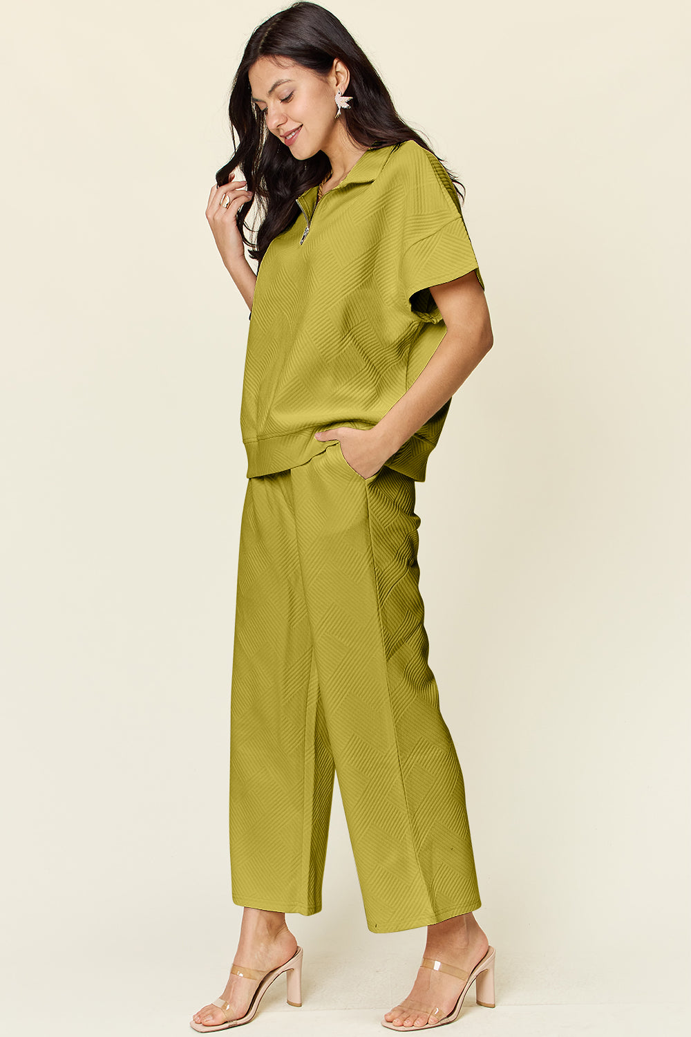 Woman wearing full-size texture half-zip short sleeve top and pants set with pockets, drawstring, slightly stretchy, in olive green.