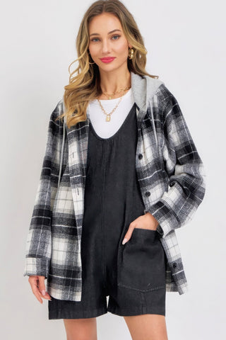 Woman wearing black denim romper with plaid jacket, casual style