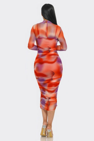 Woman wearing a Summer Heat Print Mesh Ruched Midi Dress in vibrant tomato/purple print, highlighting a flattering silhouette.