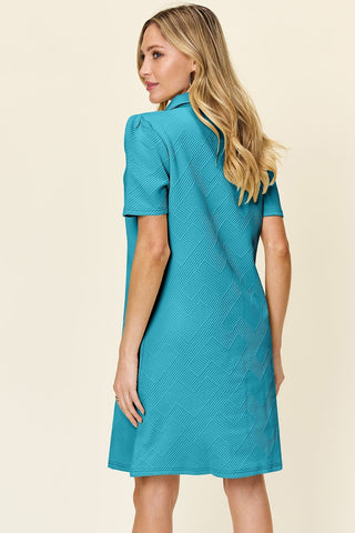 Woman wearing blue texture collared neck short sleeve dress made of 98% polyester and 2% spandex, slightly stretchy fabric.